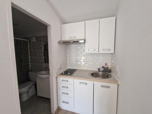 una cucina bianca con lavandino e servizi igienici di Rooms Lav a Umag (Umago)