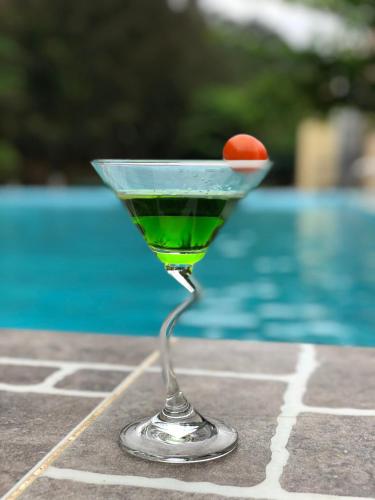 a martini glass with a cherry on it next to a pool at Hanvet Hotel Do Son in Ðố Sơn