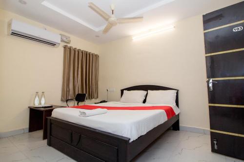 a bedroom with a bed and a ceiling fan at Pearl Suites - Located at a strategic location where Srinivasa Sethu Flyover starts and only hotel in the area to have a very spacious car parking - Skip city traffic to reach Main Temples and Airport - AC Rooms, Family Suites, Fast WiFi in Tirupati