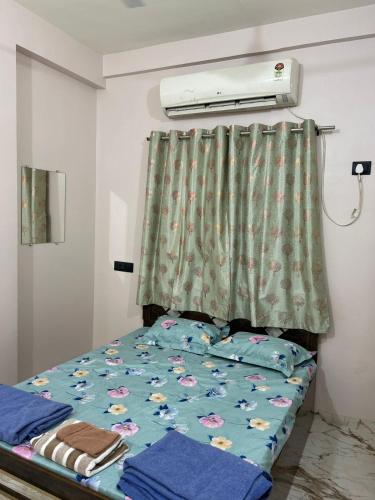 a bedroom with a bed with a green curtain at 1BHK Holiday Home in Nagpur