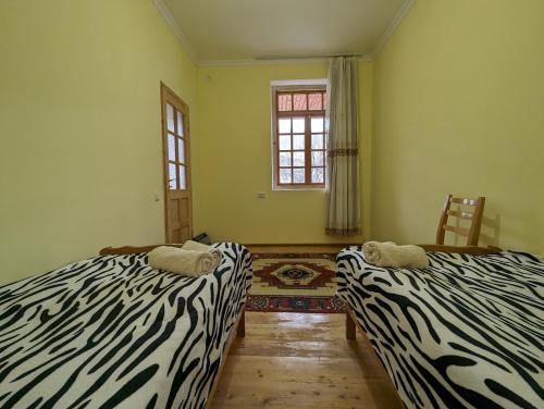 dwa łóżka w pokoju z odciskiem zebry w obiekcie Sofia w mieście Wardzia