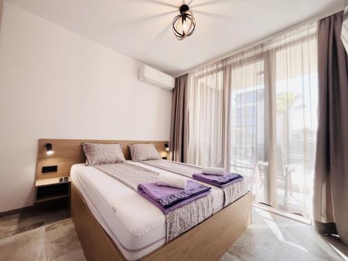 um quarto com uma cama e uma grande janela em Exclusive St Constantine Suites em Saints Constantine and Helena