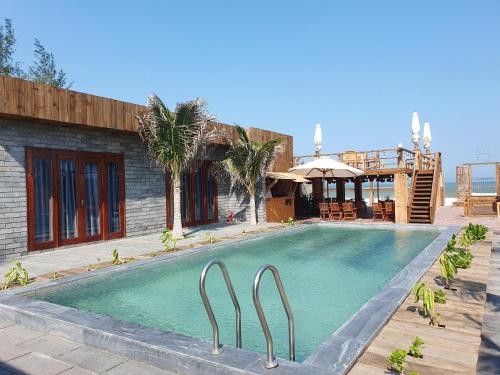 una piscina frente a una casa en Chavi Beach - Coffee and Homestay en Bình Tú