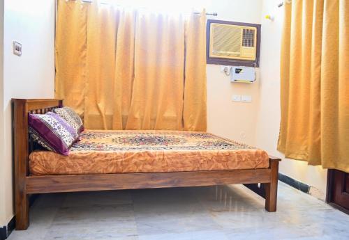 a small bed in a room with a window at Panaiyur Guest house in Chennai