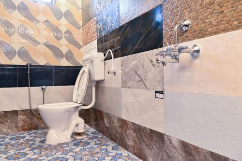 a bathroom with a toilet and a shower at Panaiyur Guest house in Chennai