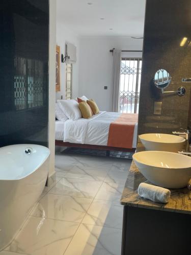 a bathroom with two sinks and a bed and a tub at D'Offay Seaview Apartments in Beau Vallon