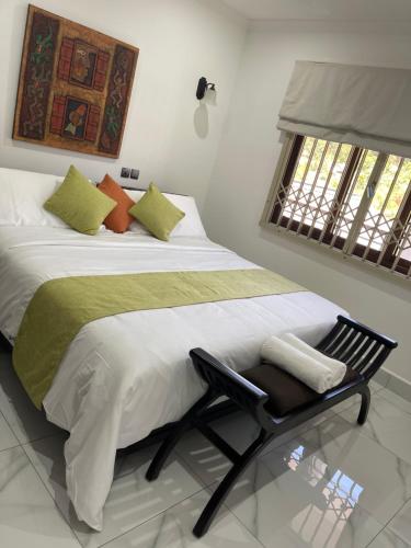 a bedroom with a large bed with a black chair at D'Offay Seaview Apartments in Beau Vallon