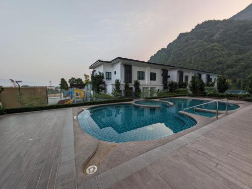 a swimming pool in front of a house at Amazing Views & Eco Friendly Luxury Onsen Suites, Lost World of Tambun in Ipoh