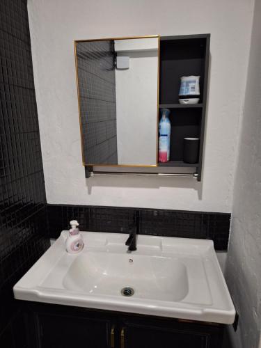 lavabo blanco en el baño con espejo en Bali-style studio apartment en Ban Madua Wan