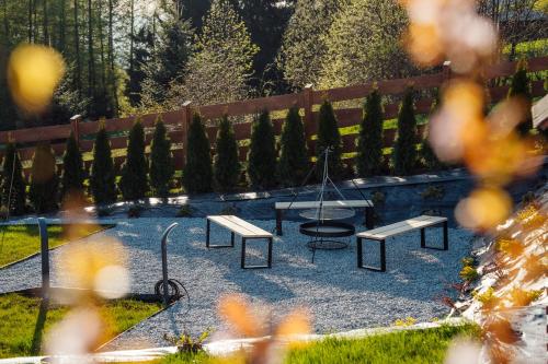 a playground with two benches and a swing at Domki Widokówki in Koniaków