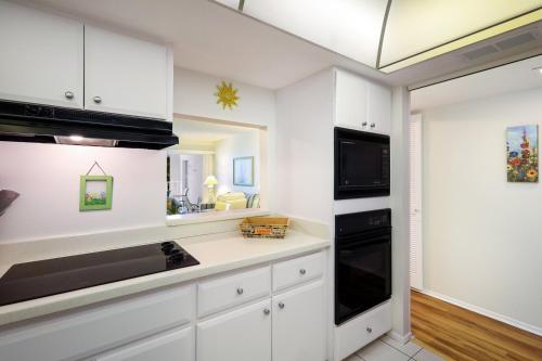 a kitchen with white cabinets and a black stove top oven at 7th Heaven condo in Longboat Key