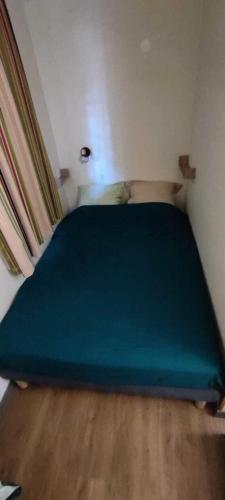 - une petite chambre avec un lit bleu dans l'établissement Résidence le Village de Cap Esterel - maeva Home - Studio 4 personnes - Sélection MAE-4173, à Saint-Raphaël