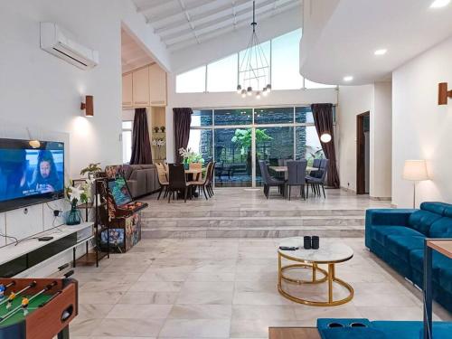 sala de estar con sofá azul y TV en KL Secret Karaoke Private Pool Villa en Ampang