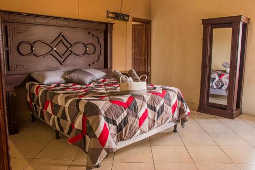 Schlafzimmer mit einem großen Bett mit einem Kopfteil aus Holz in der Unterkunft Casa Luna in Quetzaltenango