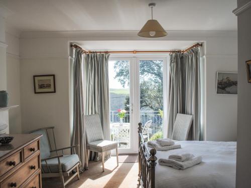 a bedroom with a bed and a large window at The Keel Row in Salcombe