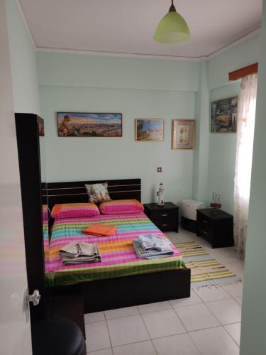DIMITRIS EYRIAKIS COTTAGE في ميتيليني: غرفة نوم مع سرير مع لحاف ملون