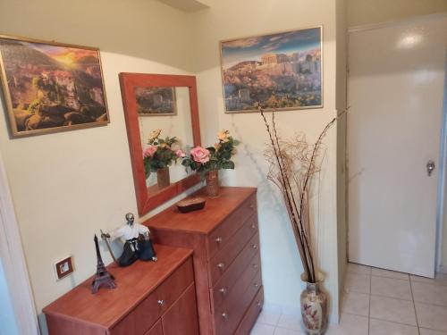 DIMITRIS EYRIAKIS COTTAGE في ميتيليني: غرفة مع خزانة مع مرآة ولوحات