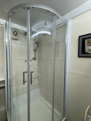 a shower with a glass door in a bathroom at Stay with Light in Ipswich