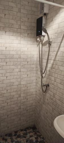 a shower in a white tiled bathroom with a sink at Dorothys in Pattaya South