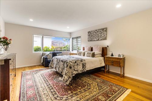 a bedroom with a bed and a large window at The Bays Bed & Breakfast in Auckland