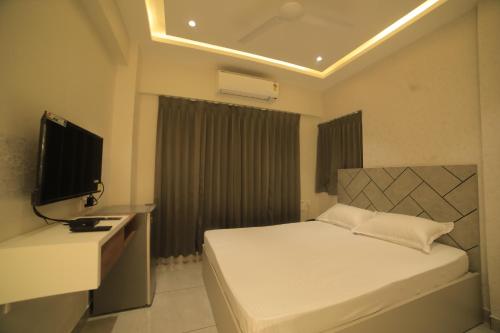 Habitación de hotel con cama y TV en K LUXURY INN, en Chennai