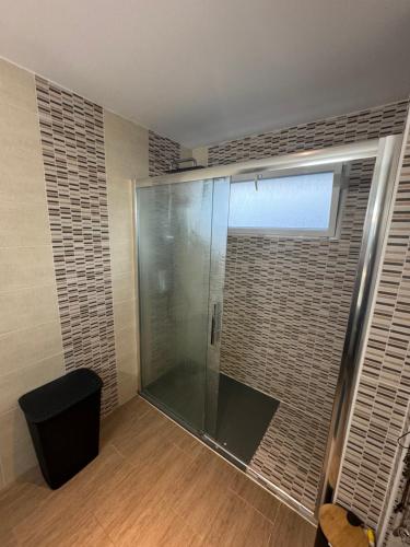 a shower with a glass door in a bathroom at Chambre chez l'habitant avec piscine 400m Circuit 24h Le Mans in Le Mans
