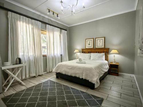 1 dormitorio con cama y ventana grande en Mitchell Guesthouse, en Pietermaritzburg