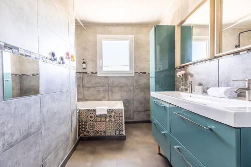 a bathroom with a sink and a bath tub at Maison 12 Couchages tout confort - 11B Vialle St Gene in Saint-Genès-Champanelle