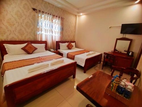 An HÃ²a的住宿－Khách Sạn Tường Vy，酒店客房设有两张床和一张桌子。