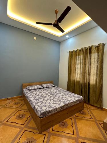 a bedroom with a bed and a ceiling fan at The Saltwater Home stay in Udupi