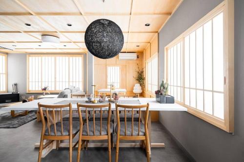 a dining room with a table and chairs and windows at THE CELESTIAL in Nakafurano