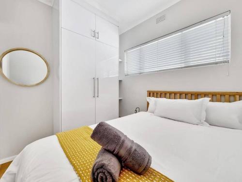a bedroom with a bed with a blanket and a mirror at Sea La Vie + Inverter+Parking in Cape Town