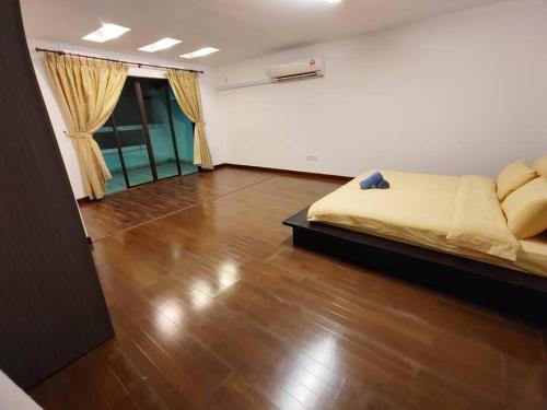 een slaapkamer met een bed en een houten vloer bij Home away from home in Miri