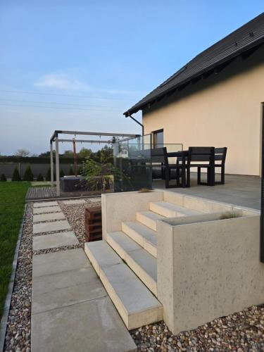 a patio with concrete steps and a table and chairs at Premium House Osztynek in Olsztynek