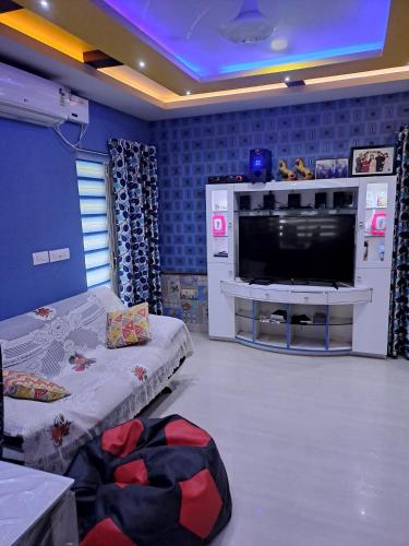 - un salon avec une grande télévision et un canapé dans l'établissement Galeela apartment Cochin, à Cochin