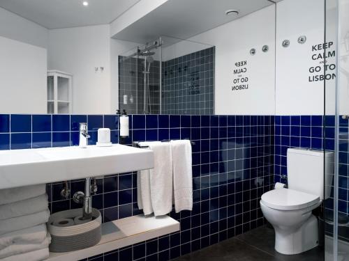 a bathroom with a sink and a toilet and blue tiles at The ART INN Lisbon in Lisbon