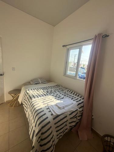 een bed in een kamer met een raam bij Karla’s Cloudspace in Ahuachapán