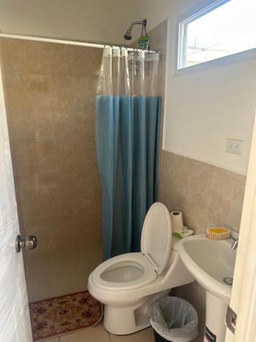 een badkamer met een toilet en een blauw douchegordijn bij Karla’s Cloudspace in Ahuachapán