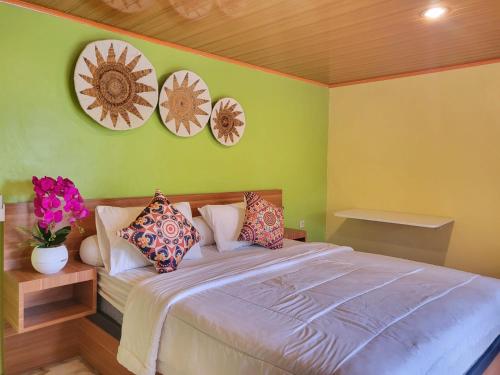 1 dormitorio con 1 cama con 4 platos en la pared en Bruri Villa, en Alor-kecil
