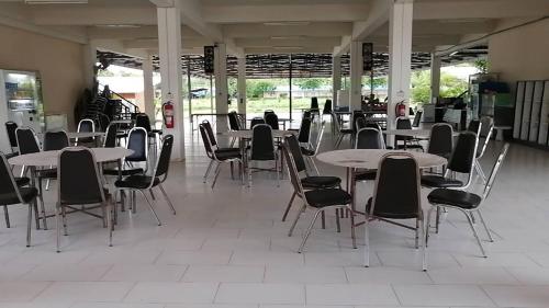 une cafétéria avec des tables et des chaises dans un bâtiment dans l'établissement ศูนย์สัมมนาอาร์มทอง, à Ban Khlong Kathon