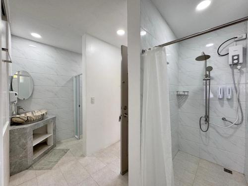 een badkamer met een douche en een wastafel bij Bale Mi Boracay in Boracay