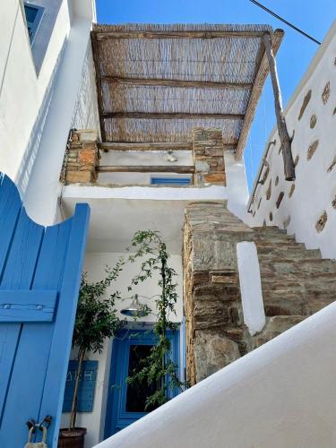 a stairway with a blue door and a window at LemonStello Kythnos in Dhriopís