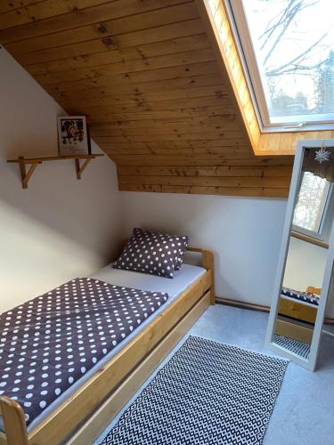 uma cama num pequeno quarto com uma janela em Apartman U vleku em Ceske Petrovice