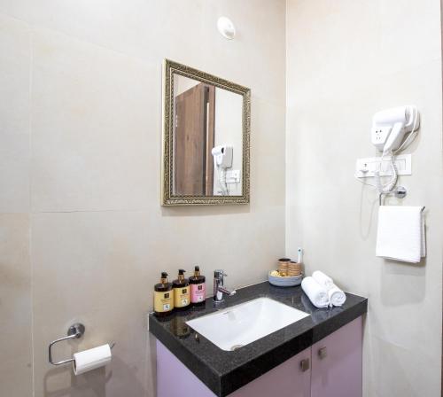 a bathroom with a sink and a mirror at ELIVAAS 2 BHK Pet Friendly Villa with Pvt Pool - Heaven in Hill in Udaipur