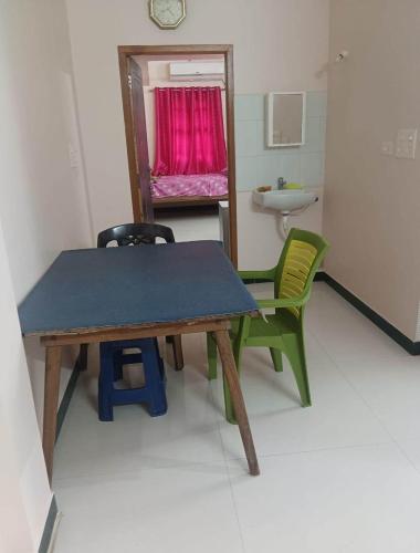 a room with a table and two chairs and a bathroom at KG Homes in Chidambaram