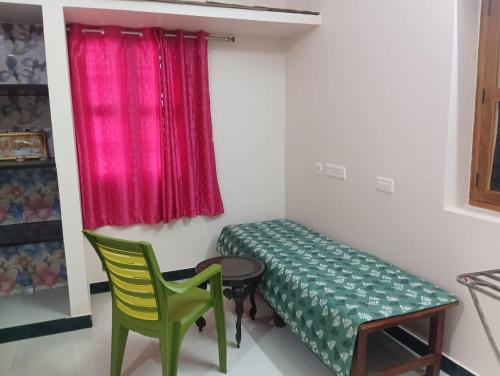 Habitación con cama, mesa y sillas. en KG Homes, en Chidambaram