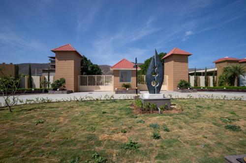 a house with a statue in the middle of a yard at Alaya Heaven in Hills Luxe 2BHK Villa with Pvt Pool, Udaipur in Udaipur