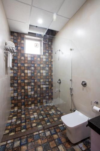 a bathroom with a shower with a toilet and a sink at ELIVAAS 2 BHK Pet Friendly Villa with Pvt Pool - Heaven in Hill in Udaipur