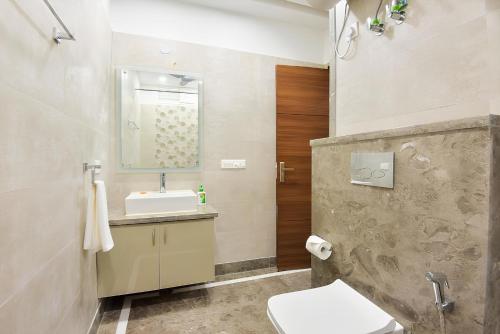 ein Bad mit einem Waschbecken und einem WC in der Unterkunft Olive Service Apartments - Golf Course Road in Gurgaon