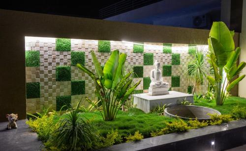 a garden with a statue in the middle of it at ELIVAAS 2 BHK Pet Friendly Villa with Pvt Pool - Heaven in Hill in Udaipur